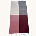 A rectangular scarf with fringed ends, divided into four equal quadrants in light beige, medium gray, dusty rose, and deep burgundy, shown flat against a white background.