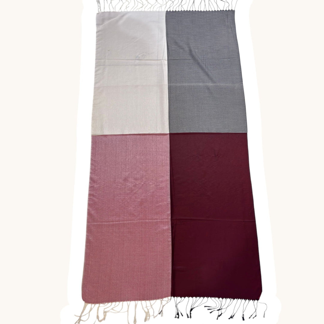 A rectangular scarf with fringed ends, divided into four equal quadrants in light beige, medium gray, dusty rose, and deep burgundy, shown flat against a white background.