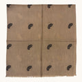 A beige woven textile with a subtle sheen and small black paisley motifs repeated across the surface, shown flat against a plain light background.