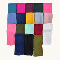 A grid of 24 folded fabric swatches in various colors, including teal, magenta, burgundy, green, pink, blue, yellow, gray, light pink, olive green, mint green, red, and white, arranged on a light cream background.
