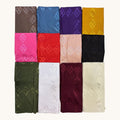 Twelve folded fabric pieces arranged in a 3-by-4 grid on a plain light background. The fabrics show a woven diamond pattern in various colors including brown, blue, purple, mustard yellow, pink, red, light beige, black, olive green, white, burgundy, and cream.
