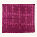 A rectangular magenta purple fabric, likely a silk scarf or sari, featuring a repeating pattern of vertical columns of pink diamond (ikat) motifs, displayed flat against a light cream background.